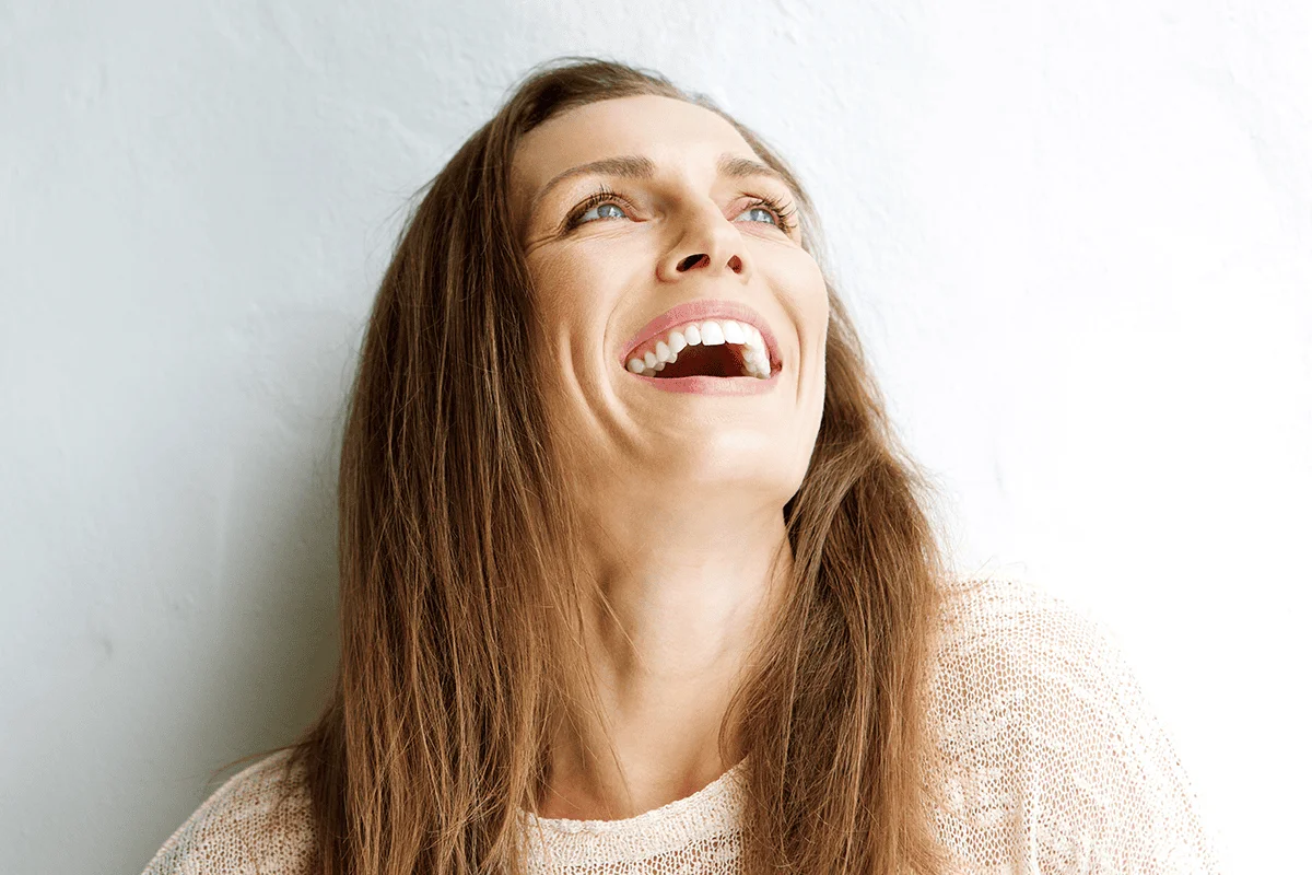 Woman looking up and smiling on a well lit white background