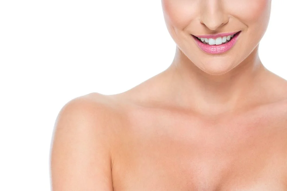 woman smiling with shoulders showing decolletage area